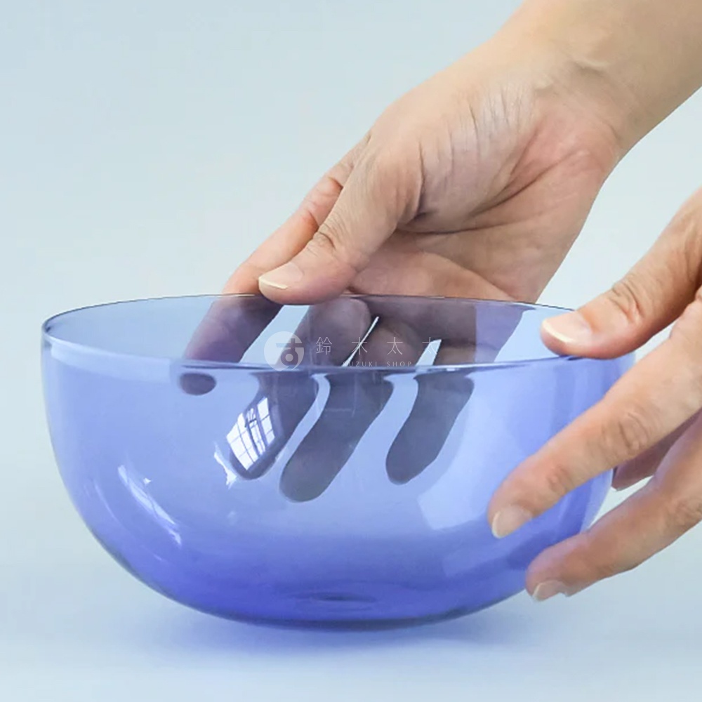 一雙手捧著一個透明的紫色圓潤玻璃點心碗，碗身呈現柔和的弧度，材質光滑，光線透過碗身，在內部形成反射。