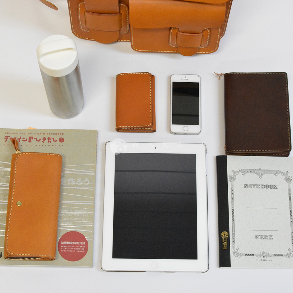 職人手作皮革單肩包，搭配多種皮革配件：卡夾、手機、筆記本、平板電腦及保溫瓶。