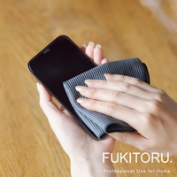 雙手持深灰色超細纖維清潔布擦拭黑色手機螢幕。