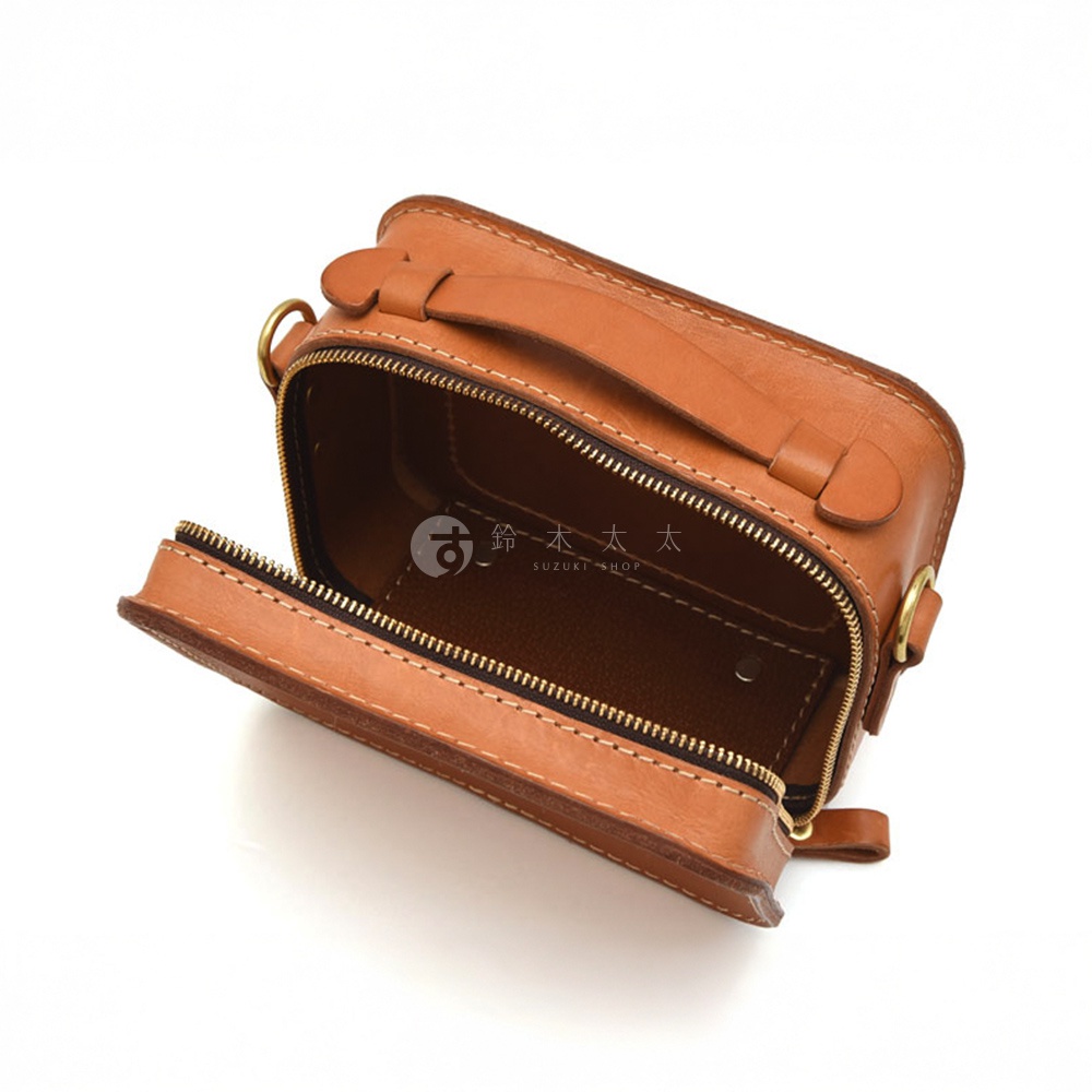 職人手作皮革兩用迷你小方包 CW-40，棕色皮革，正面拉鍊開啟，露出內部空間，側邊有金屬扣環，上方有手提把，精緻縫線細節，上面印有「SUZUKI SHOP」及日文文字。