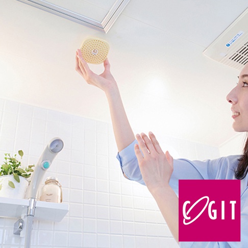 一位女士將一個圓形、淺黃色的可掛式除臭防霉除濕貼片盒，固定在浴室天花板上。貼片盒表面有許多小孔。