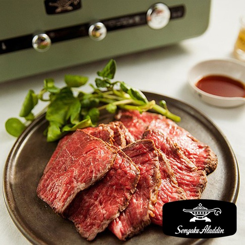 盤中擺放著切片烤牛肉，佐以綠色水芹菜，背景為一台簡約白的復古多用途烤箱。