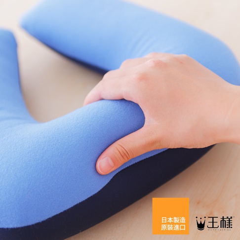 藍色U型枕，觸感柔軟，由人手按壓展示其材質。