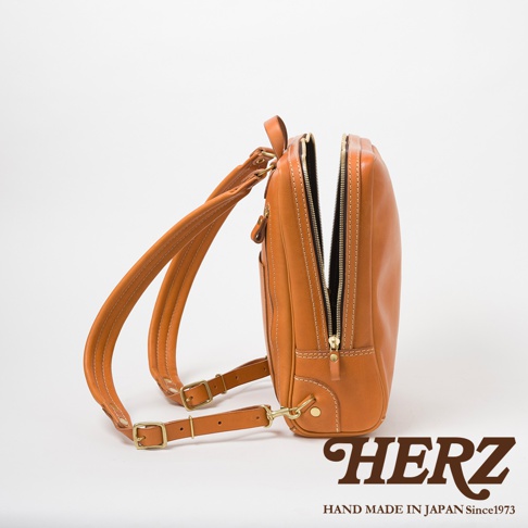 職人手作棕色皮革商務後背包，展示其柔軟的皮革材質、銀色拉鍊和金屬扣環，以及縫線細節。