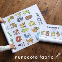 一張展開的白色無框帆布藝術海報，上面印有以動物夥伴組成的字母圖案，色彩鮮豔，包括獅子、熊、貓、鹿、大象、猴子、蜥蜴、無尾熊、水母、烏龜、熊貓等，字體為「ANIPHABET WILD LIFE」。