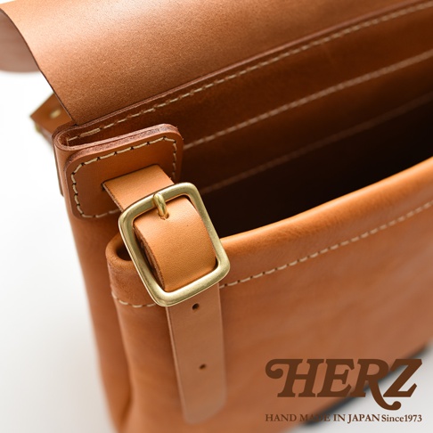 職人手作皮革經典郵差包 CK-4 M，採用溫暖的棕色皮革，搭配黃銅色金屬釦環，縫線精緻，設計簡約實用。