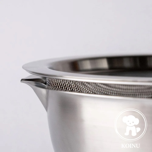 不鏽鋼濾水網與刻度料理盆的特寫，展示盆邊緣的細緻網孔和導流口，盆體表面光滑，帶有白色小狗商標。