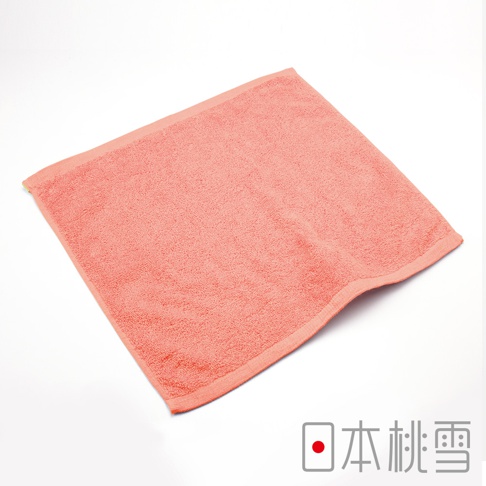 珊瑚粉色飯店方巾，觸感柔軟，材質為純棉，邊緣有細緻的縫線。