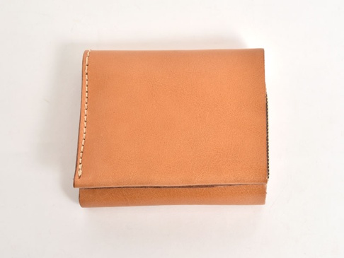 淺棕色皮革直式卡片收納雙折短夾，展現自然紋理與手工縫線，簡約設計，適合日常攜帶。
