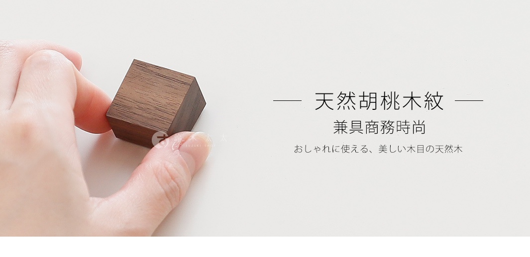 一只手拿著一個天然實木製成的深棕色立方體筆電散熱塊，木紋清晰可見。