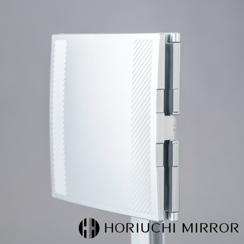 銀色金屬材質的NAPURE桌上型三折化妝鏡，鏡面有斜紋及碳纖維紋路裝飾，鏡面左側有兩道白色裝飾條，整體設計簡潔現代。