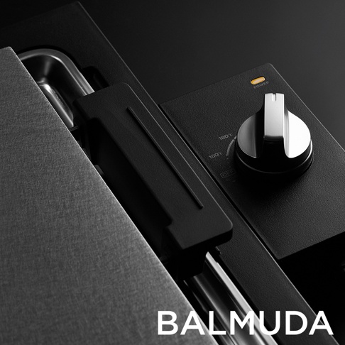 極致電烤盤 (黑色) 的近攝，顯示其部分黑色霧面機身、銀色旋鈕式溫度控制器（標有 160°C、180°C 和 OFF 字樣），以及一個黃色電源指示燈。機身一側可見不鏽鋼烤盤。