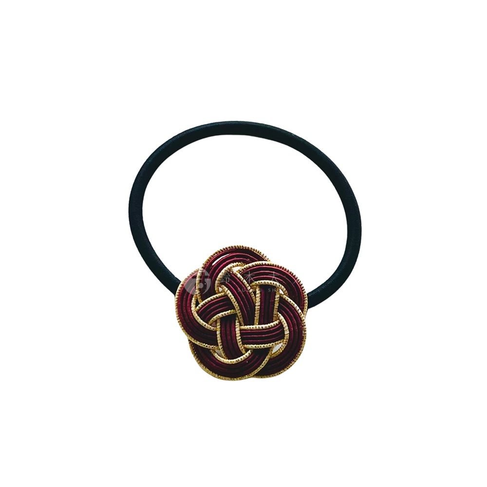 黑色髮圈搭配一個酒紅色與金絲編織而成的日式水引花結飾品。