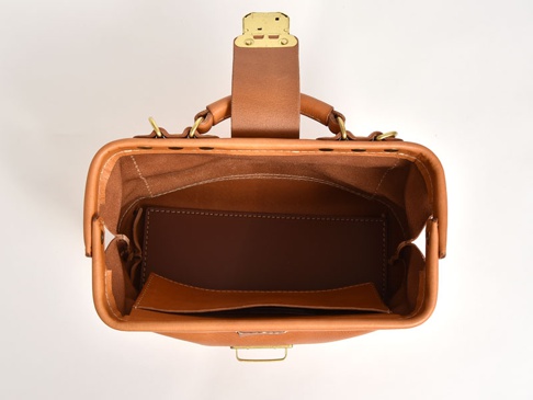 職人手作皮革兩用迷你口金單肩包 (CW-7)，呈現經典棕色，全真皮材質，包身結構方正，頂部設有金屬旋轉鎖扣及皮革提把，內部分層明細，展現細緻縫線工藝。