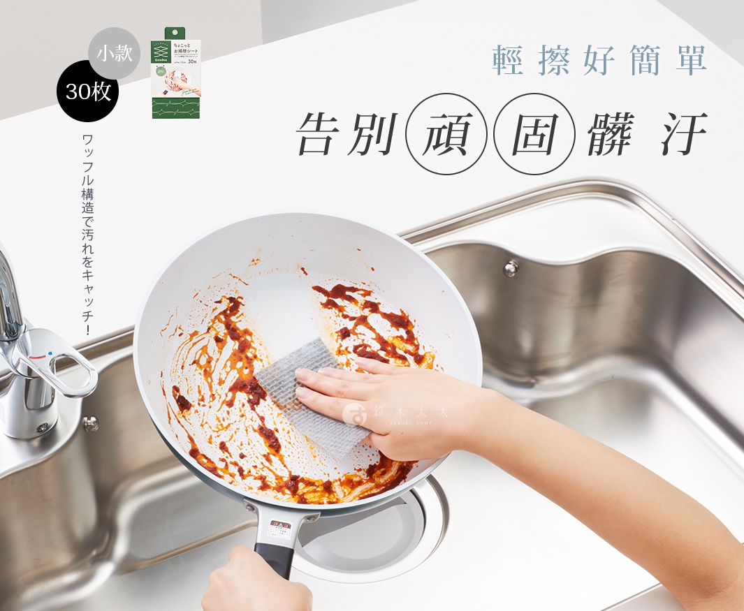 手持鬆餅紋潔淨海綿巾，正在擦拭沾有醬料的白色鍋具，鍋具置於不鏽鋼水槽旁。海綿巾為淺灰色，呈現格子狀紋理。
