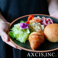 黑色陶瓷主菜盤裝有沙拉、可頌、麵包、火腿片和馬鈴薯沙拉，盤緣有淺棕色邊飾。