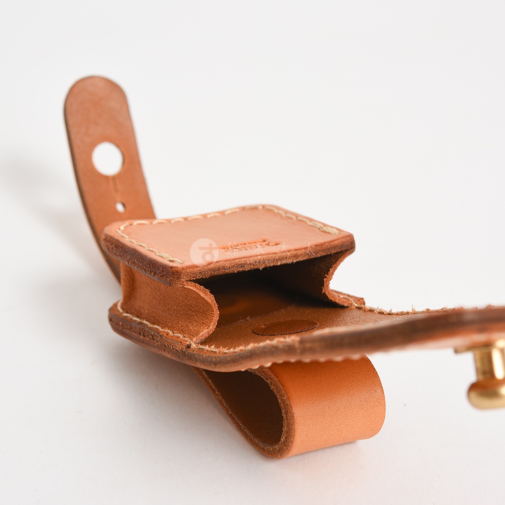 職人手作皮革原子釦型腰間小物收納包，淺棕色皮革，帶有縫線細節，可掛於腰帶上，用於收納小物。