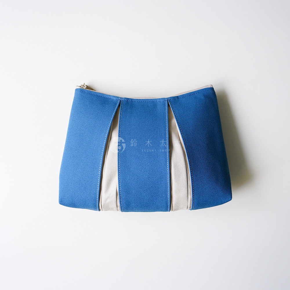 這款京都KOSHO ougi帆布化妝收納包L採用簡約設計，以深藍色與米白色帆布拼接而成，包身結構具備立體褶皺感，配有頂部拉鍊開口，整體呈現出清新自然的日式風格，非常適合作為日常收納使用。