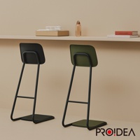 兩張STAN CHAIR人體工學站立椅，一張為黑色椅面與黑色椅架，另一張為軍綠色椅面與黑色椅架。椅面為簡潔的方形設計，椅架為金屬材質，呈現簡約線條。