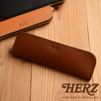 職人手作皮革托盤式收納筆袋KP-5，共有三種尺寸及五種顏色可選。此圖片展示了三款不同顏色的筆袋，分別為深棕色、淺棕色及黑色，皆採用高品質皮革製作，並壓印有HERZ品牌標誌。筆袋設計簡約，配有拉鍊開合，方便收納。