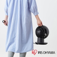 黑色圓形空氣循環扇，帶有黑色底座和網狀扇葉護罩，由一名身穿藍白條紋連衣裙的人士手持。