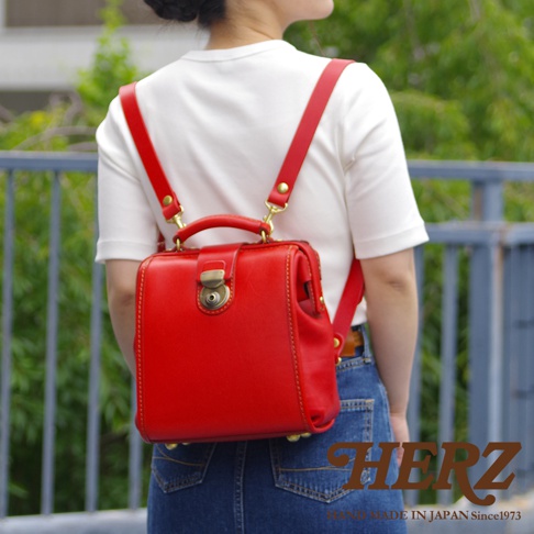 職人手作紅色皮革迷你後背醫生包，帶有經典鎖扣和金屬配件，展現精緻工藝。