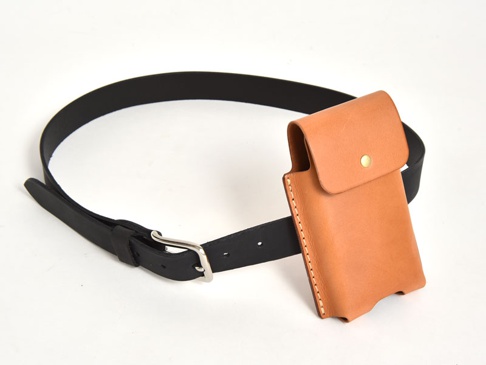職人手作皮革三用手機收納包，搭配黑色皮革皮帶。手機包為淺棕色皮革材質，設有翻蓋及一顆金色銅釦，可掛於皮帶上使用。