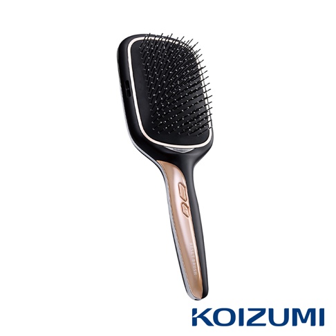黑色與金色結合的離子養髮梳，梳頭有密集的黑色梳齒，手柄處有兩個按鈕和刻有RESET BRUSH字樣的金色飾條，底部有KOIZUMI品牌標誌