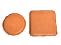 職人手作皮革方形坐墊 (KZ-6) 2，展示了兩個皮革坐墊，一個圓形，一個方形，皆為淺棕色，表面光滑，邊緣有細緻縫線。