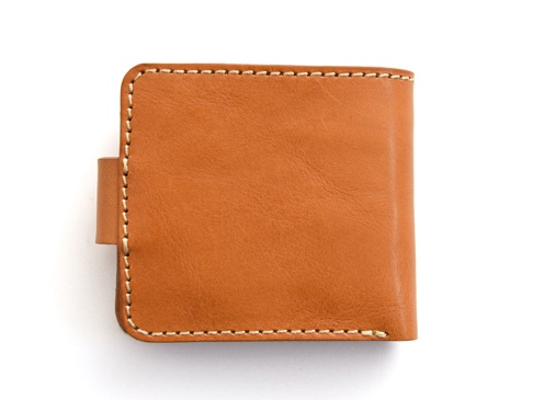 焦糖色皮革短夾，以手工縫線圍邊，側邊有一個可拆卸的皮革繫帶。