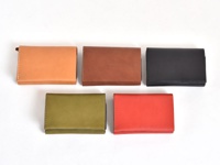 五個職人手作皮革中型雙折短夾，顏色分別為淺棕色、咖啡色、黑色、橄欖綠和紅色。