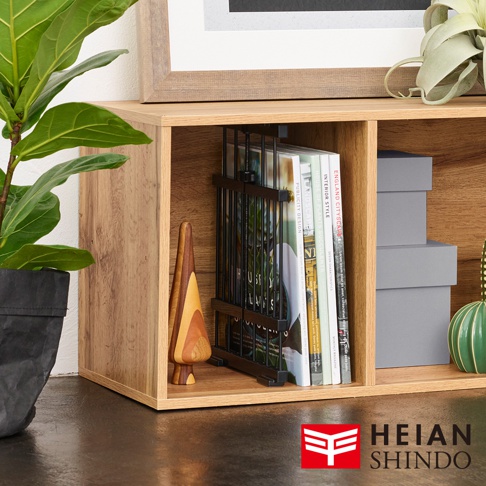 淺木紋層架內，黑色金屬網狀置物架整齊擺放多本雜誌，右側有灰色紙盒堆疊。