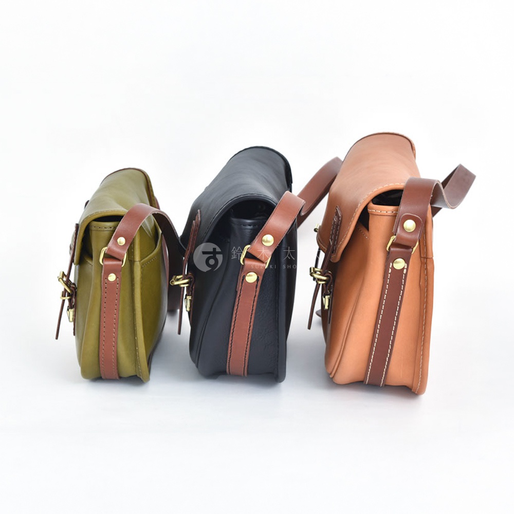 三款職人手作皮革傳統釣魚包，分別為橄欖綠、黑色和棕褐色，皆配有咖啡色皮革飾邊及黃銅金屬釦件。