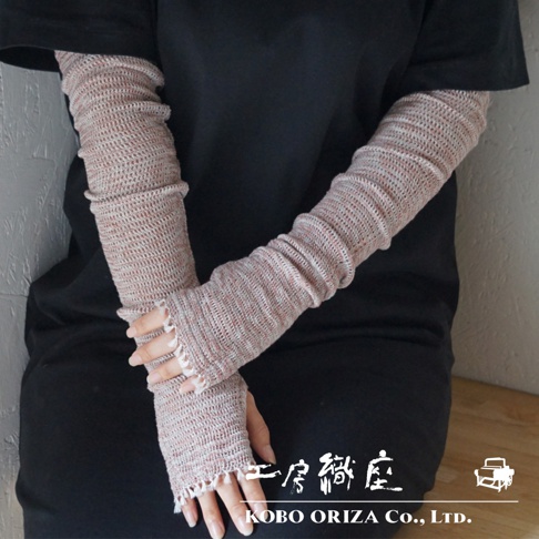 一雙淺粉色與白色交織的輕柔針織袖套，覆蓋至手肘，袖口有細緻的蕾絲荷葉邊設計，露出手指。