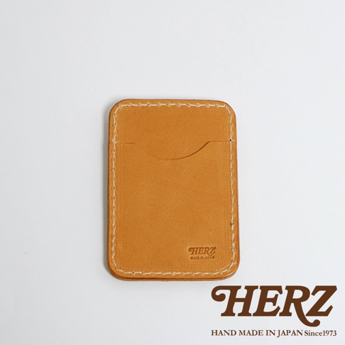 一個棕褐色的皮革名片夾，有著手工縫線細節，下方印有品牌標誌。