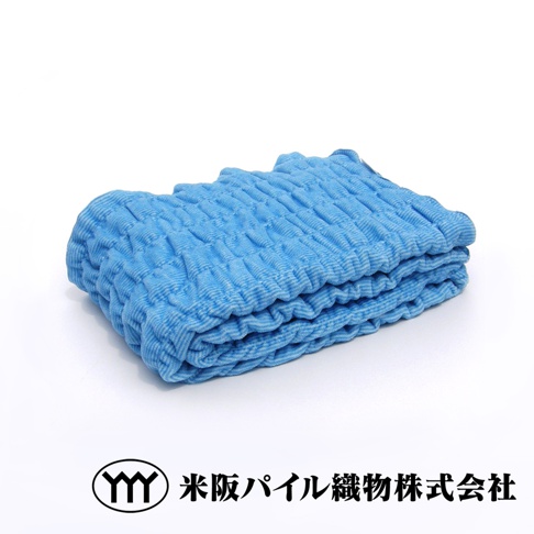 藍色細絨材質的四季毯，表面有獨特的波浪紋理，毯子整齊對折，呈現柔軟的質感。