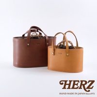 兩款職人手作皮革束口手提包，一款為深棕色，另一款為淺棕色。均採用天然皮革材質，設有束口內袋和雙提把設計。