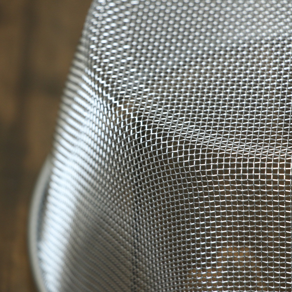 不鏽鋼濾網的細緻網孔特寫，呈現金屬光澤，部分區域有模糊的背景。
