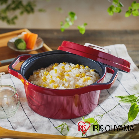 紅色COTOCO萬用無水調理鍋20cm，鍋內盛有白米飯和玉米粒，鍋蓋為紅色，鍋身為紅色琺瑯鑄鐵材質，帶有黑色把手，鍋內為黑色塗層。