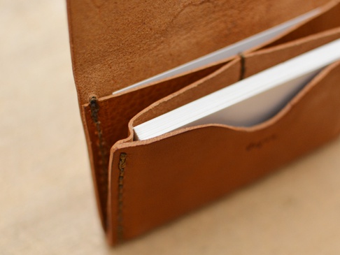 職人手作皮革Organ薄型名片短夾，採用棕褐色皮革製成，內含多個夾層，可收納名片。皮革表面紋理自然，縫線清晰。