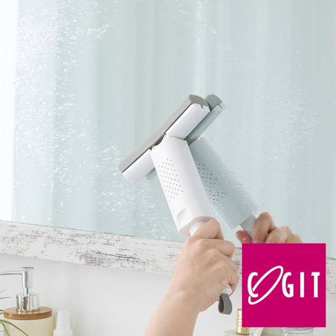 一隻手正握著白色推拉式海綿刷，刷頭為灰色與白色組合，正在清潔帶有水漬的玻璃表面。