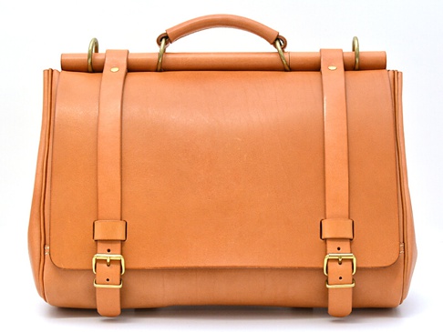 一個淺棕色皮革製成的三用側背包，配有頂部提把、可調節式肩帶和金色搭扣。
