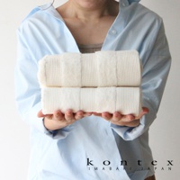 雙色今治雙織有機棉毛巾，以鬆餅紋織法呈現，質地柔軟，兩條毛巾疊放，由雙手捧持。