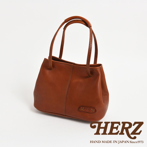 HERZ 職人手作皮革托特包，搭配品牌標誌，手提肩背兩用，日本製造。