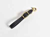 黑色皮革製成的手作可調式吊掛帶，配有黃銅色金屬鉤扣和方形調節環，帶有兩個調節孔。