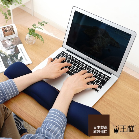 深藍色減壓護腕枕，柔軟材質，可支撐手腕，搭配筆記型電腦使用。