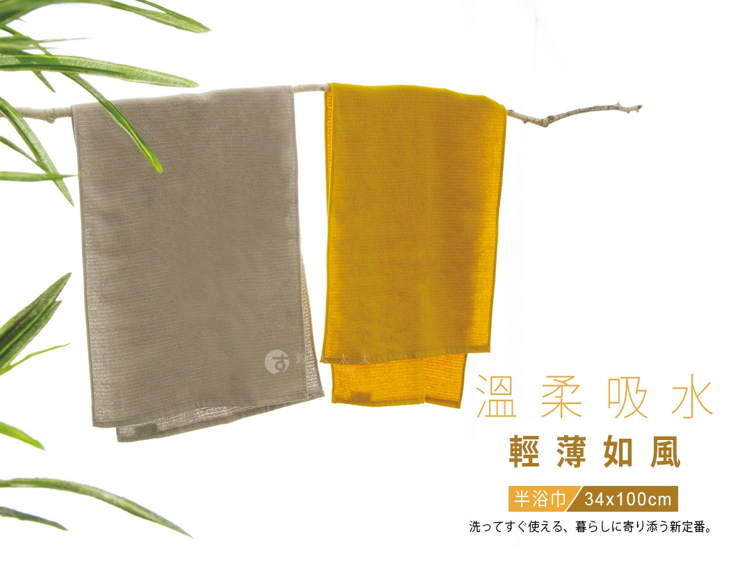 一條灰色與一條黃色的長方形棉質半浴巾懸掛在木枝上，背景為簡約的白色，圖中文字說明該浴巾尺寸為三十四乘以一百公分，主打溫柔吸水與輕薄質感。