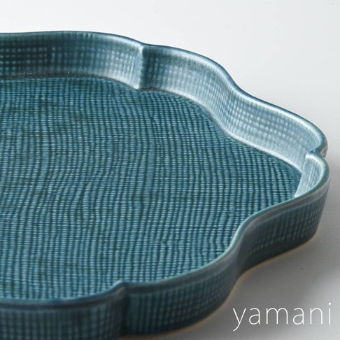 藍色美濃燒花型主食盤，盤面有細密的縱向紋理，盤緣為波浪狀，材質為陶瓷。