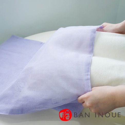 雙層蚊帳棉織親膚枕套，左側為淺紫色蚊帳材質，右側為奶油色枕頭，雙手正將蚊帳鋪展在枕頭上。