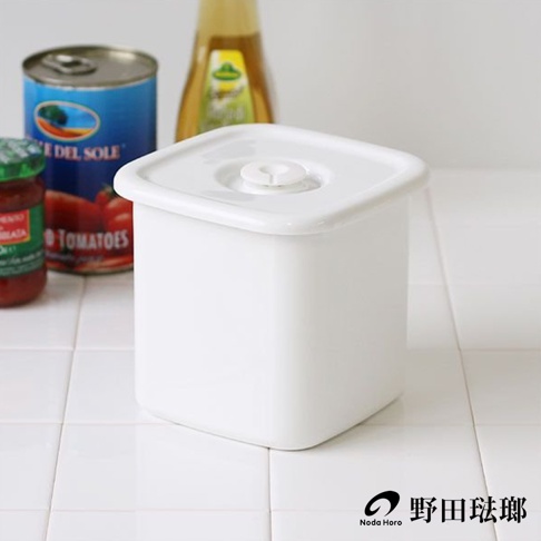 白色方形琺瑯保存容器，帶有圓形白色密封蓋，置於白色瓷磚檯面上，背景有罐頭和瓶子。